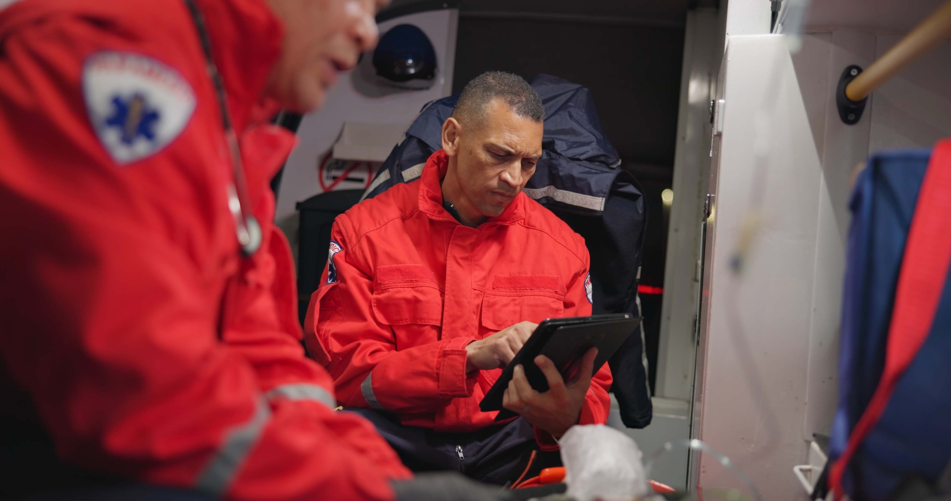 First Responder with tablet evaluating rescue equipment needs, healthcare with technology, communication and doctor update. Ems, accident and victim with oxygen mask, digital medical service and transportation